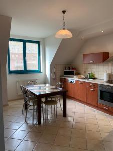 a kitchen with a table and chairs in a kitchen at Apartamenty Staromłyńska in Szczecin