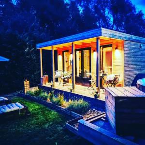 une petite maison avec une terrasse couverte ouverte la nuit dans l'établissement Au Pré de Mukky, à Andenne