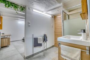 Sous-sol aménagé 32m2 - Proche Paris في أوبارفيلييه: حمام مع حوض ومرآة