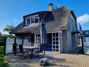 a table and chairs with an umbrella in front of a house at Prachtig vakantiehuis in Domburg DO38 in Domburg
