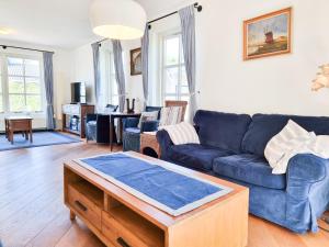 a living room with a blue couch and a table at Prachtig vakantiehuis in Domburg DO38 in Domburg