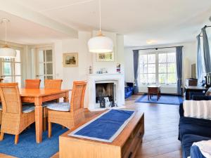 a living room with a table and chairs and a fireplace at Prachtig vakantiehuis in Domburg DO38 in Domburg