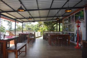 un restaurant avec des tables et des chaises en bois et des fenêtres dans l'établissement Ibni Springs, à Madikeri