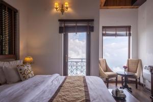 a bedroom with a bed and two windows with a view at StayVista at Slice of Heaven with Heater in Mussoorie in Mussoorie