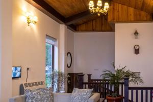 a living room with a couch and a chandelier at StayVista at Slice of Heaven with Heater in Mussoorie in Mussoorie