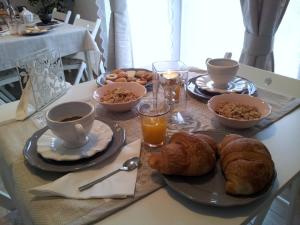 a table with a breakfast of coffee and croissants at Dear Venice Bed & Breakfast in Marghera