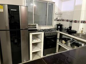 a kitchen with a refrigerator and a stove top oven at Apartamento amoblado a 10 minutos del centro in Bogotá