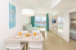 a dining room with a table and chairs and a bedroom at HSM Calas Park in Calas de Mallorca