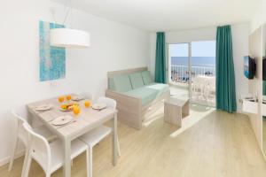 a living room with a table and a room with a bed at HSM Calas Park in Calas de Mallorca