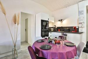 una mesa con un mantel púrpura en ella en una cocina en Le Cosy T2 hypercentre PARKING INCLUS ! la plage à 2 min !, en Les Sables-dʼOlonne