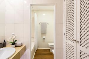 La salle de bains blanche est pourvue d'un lavabo et de toilettes. dans l'établissement Micampus Armendariz Student Residence, à Séville