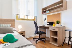 1 dormitorio con 1 cama y escritorio con ordenador en Micampus Armendariz Student Residence, en Sevilla