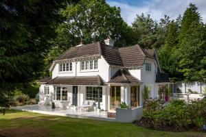 una gran casa blanca con techo en Ridge Cottage, en Bransgore