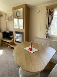 una mesa de madera en una sala de estar con mesa y sillas en Beautiful Butlins van, en Lincolnshire