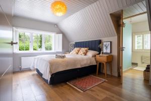 1 dormitorio con 1 cama extragrande y ventana en Ridge Cottage, en Bransgore