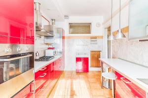 a kitchen with red cabinets and white appliances at JJ's Place in Trieste