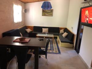 a living room with a table and a couch at Holiday Home Idyllic Cottage in Čanj