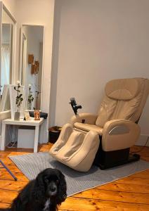 a black dog sitting in front of a reclining chair at -- La main à la pâte -- in Boulogne-sur-Mer