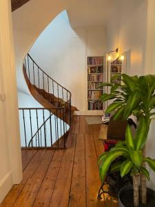 a living room with a wooden floor and a spiral staircase at -- La main à la pâte -- in Boulogne-sur-Mer