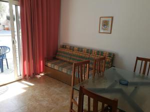 salon z kanapą, stołem i krzesłami w obiekcie Apartment with community pool for 4 people - Riells area w mieście L'Escala