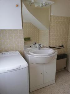 een badkamer met wastafel en wasmachine bij Chez Mi, centre ville, parking gratuit, arrivée autonome in Saint-Chinian