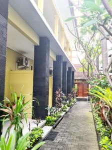 un patio de un edificio con plantas y una pasarela en Guest house KupuKupu39, en Kuta
