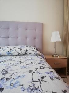 een slaapkamer met een bed met een blauw en wit dekbed bij Chez Mi, centre ville, parking gratuit, arrivée autonome in Saint-Chinian