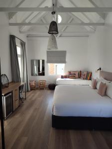 Cape Town的住宿－iGadi House Boutique Hotel，一间大卧室,配有两张床和一张桌子