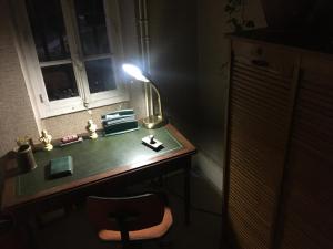 a desk with a lamp and a chair in a dark room at Gamotel in Vitteaux