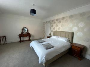 a bedroom with a large white bed and a mirror at Number 29, Westgate-on-Sea in Westgate on Sea