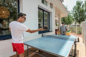 a man playing ping pong on a ping pong table at Pins Platja Apartments in Cambrils