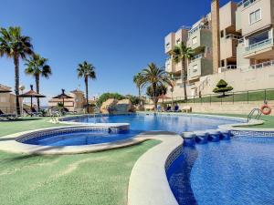 a swimming pool at a resort with palm trees and buildings at Cala Azul -7909 in Cabo de Palos