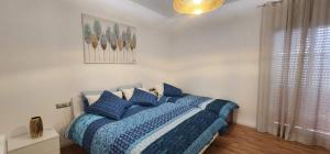 a bedroom with a blue bed with blue pillows at Appartamento Agrumi in Linguaglossa