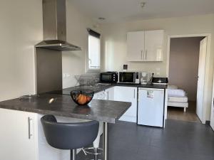 a kitchen with white appliances and a counter top at T1 bis confortable avec parking et animaux acceptés - FR-1-495-111 in Cambo-les-Bains +5 photos