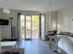 a kitchen with a table and a view of a patio at T1 bis confortable avec parking et animaux acceptés - FR-1-495-111 in Cambo-les-Bains