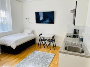a kitchen with a sink and a bed in a room at Midland Apartment- Studio in Leicester