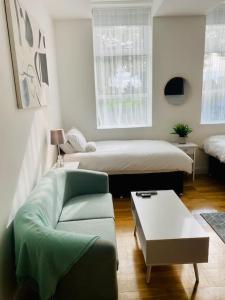 salon z łóżkiem i kanapą w obiekcie Midland Apartment- Studio w mieście Leicester