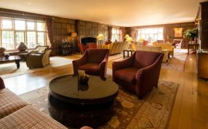 a living room with couches and chairs and a table at Whatley Manor in Malmesbury