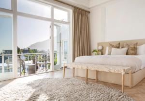 a bedroom with a large bed and a large window at The Clarendon - Fresnaye in Cape Town