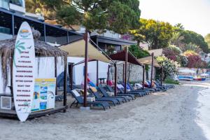 eine Reihe von Stühlen und Sonnenschirmen am Strand in der Unterkunft SIGNATURE BLUE RESORT in Kusadası