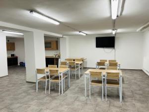 a room with tables and chairs and a flat screen tv at Hostel H18 in Bardejov