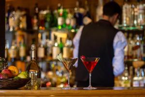 two martini glasses sitting on a bar with a bartender at Whatley Manor in Malmesbury
