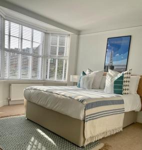 a bedroom with a large bed in a room with windows at Neap Tide in Rye