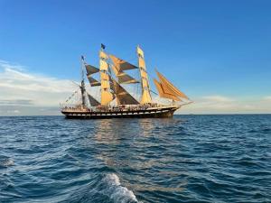 a large sail boat sitting in the middle of the ocean at Neap Tide in Rye