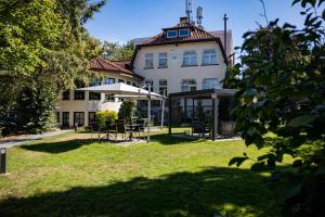 ein Haus mit einem Tisch und einem Sonnenschirm im Hof in der Unterkunft Hotel Stadt Hamburg in Bad Salzuflen