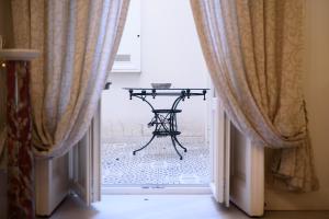 a table in the doorway of a room with curtains at Palazzo dello Spagnolo Suite in Naples