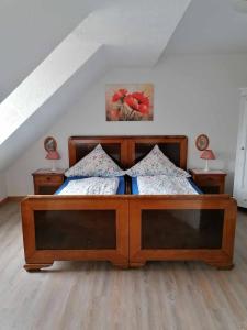 a bedroom with a wooden bed with two lamps at Pension Gestüt Morgenstern in Hameln