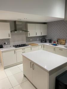 a kitchen with white cabinets and a white counter top at The Townhouse @Thorpe Road in Peterborough