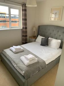 1 dormitorio con 1 cama con 2 toallas en Blue Sky Apartments @Wallis Square, Farnborough, en Farnborough