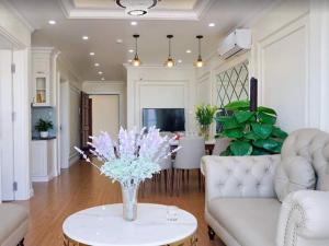 una sala de estar con un jarrón de flores sobre una mesa en Homestay Ha Long luxury (sea ​​view) en Ha Long